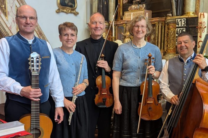 Mitglieder der d'Salmdorfer Stubenmusi mit Gitarre, Querflöte, Geige, Bratsche und Kontrabass in der Kirche Mariä Himmelfahrt in Salmdorf.